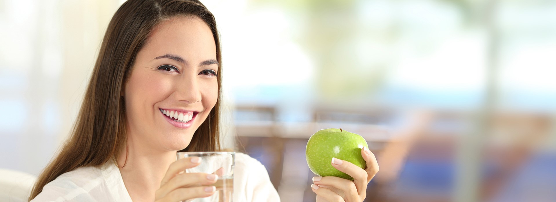 Frau mit Wasserglas und grünem Apfel